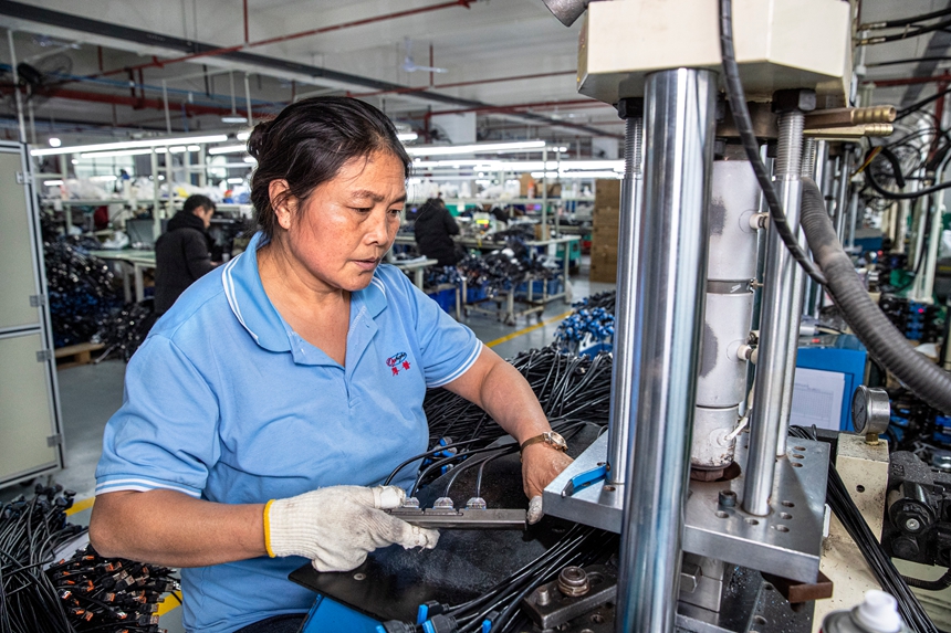 2025年12月17日，工人在貴州省金沙縣經(jīng)濟(jì)開發(fā)區(qū)一家數(shù)據(jù)線生產(chǎn)企業(yè)車間生產(chǎn)線上作業(yè)。