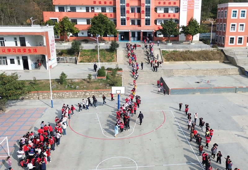 師生在進行火災(zāi)疏散逃生演練。