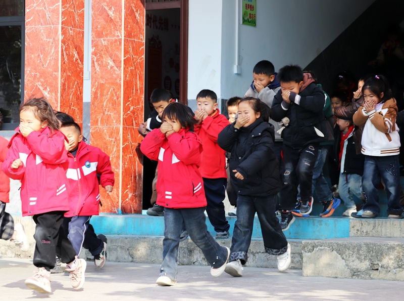 師生在進行火災(zāi)疏散逃生演練。