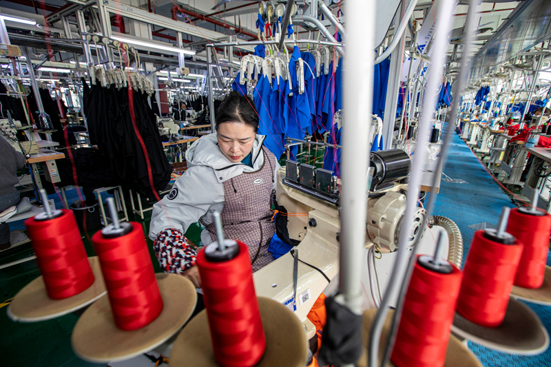 工人在貴州省畢節(jié)市黔西市經(jīng)濟(jì)開發(fā)區(qū)一家服飾企業(yè)車間生產(chǎn)線上加工服飾。