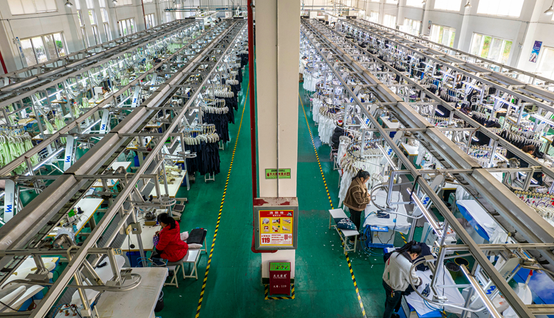 工人在貴州省畢節(jié)市黔西市經(jīng)濟開發(fā)區(qū)一家服飾企業(yè)車間生產(chǎn)線上加工服飾。