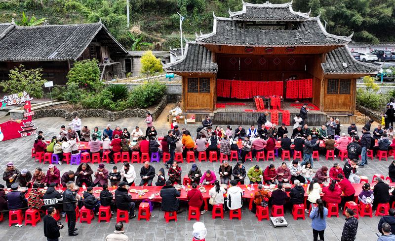 2025年12月21日，貴州省銅仁市玉屏侗族自治縣新店鎮(zhèn)大灣村，游客和村民在品嘗長(zhǎng)桌宴。