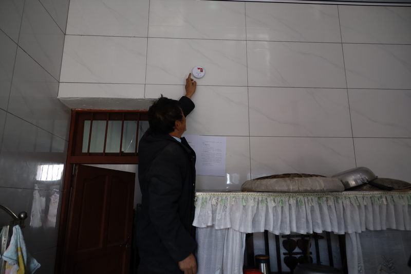 板底鄉曙光村群眾查看家里的一氧化碳報警器。