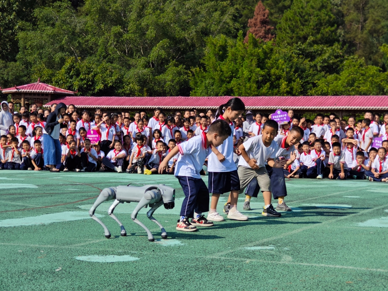 羅甸：人工智能進(jìn)校園 ，點(diǎn)亮少年科技?jí)簟D為學(xué)生與機(jī)器狗賽跑。 秦正蘇、陳由醒供圖.jpg