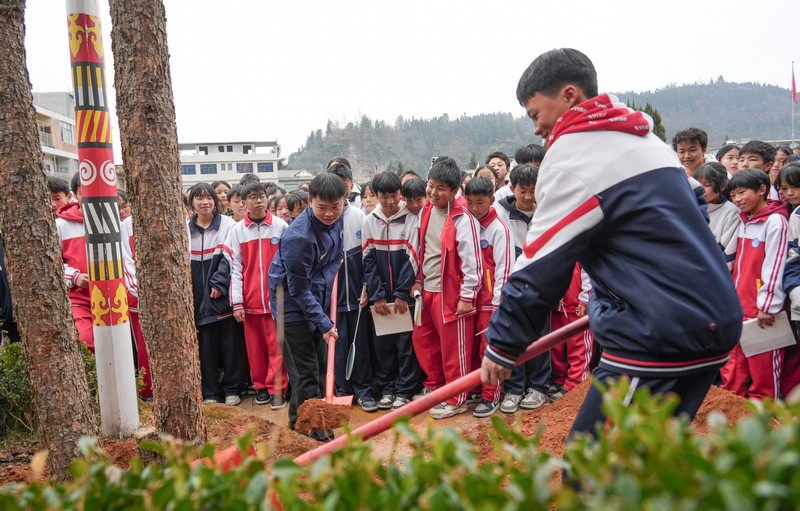 2025年12月24日,貴州省畢節市納雍縣化作中學,納雍籍奧運冠軍謝瑜在和學生一起種樹。