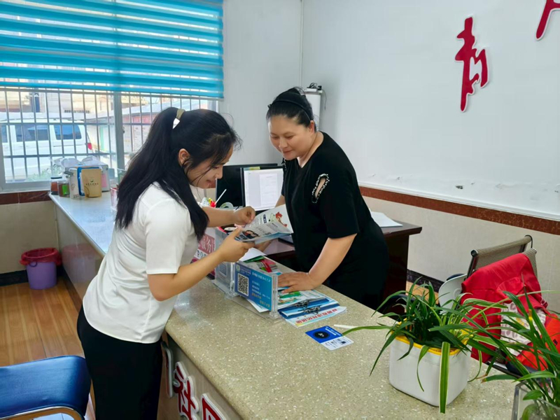 施秉縣一社區(qū)工作人員在為市民辦理業(yè)務(wù)、宣傳相關(guān)政策。