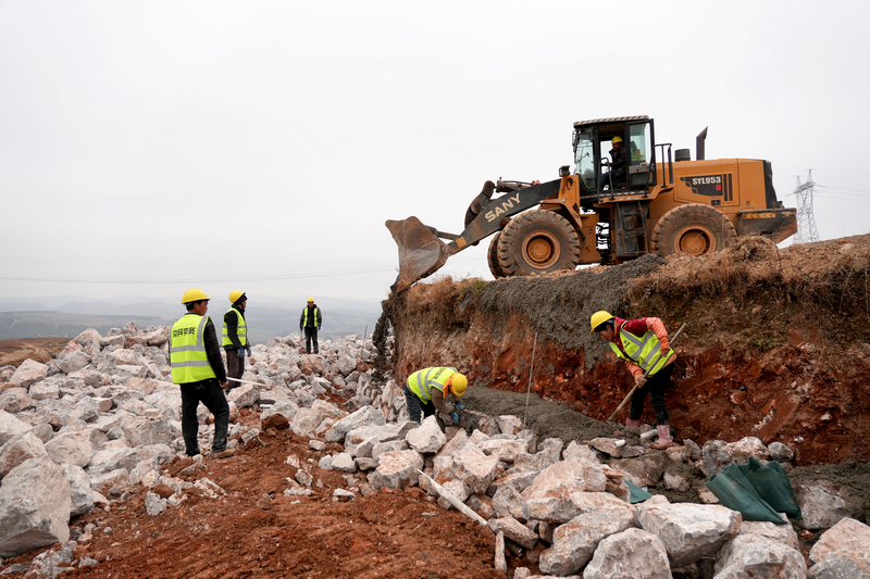 12月24日，在威寧自治縣2025年高標準農田建設項目迤那鎮櫻桃村項目區，人機協同作業，緊張砌筑田坎。陳逍攝