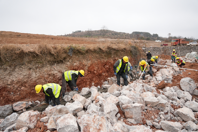 12月24日，在威寧自治縣2025年高標準農田建設項目迤那鎮櫻桃村項目區，施工人員分工協作，正在砌筑田坎。陳逍攝