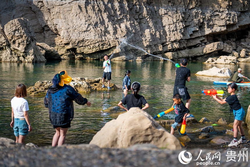 5 2025年5月2日,“五一”節期間,游客在貴州省安順市普定縣貓洞村三岔河的淺灘處在戲水嬉戲。人民網記者 涂敏 攝