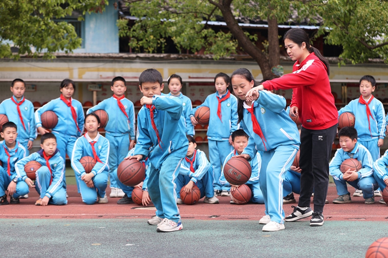學生在老師的指導下練習運球。