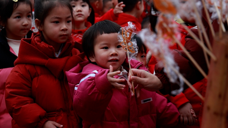 孩子開心領取傳統糖畫品嘗。