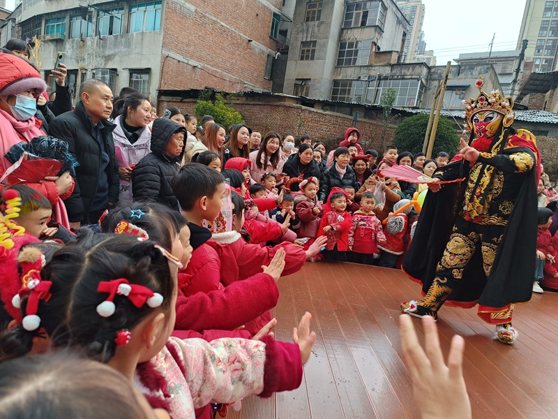 3、川劇變臉亮相游園會，孩童們伸手互動樂不停。習水縣融媒體中心供圖