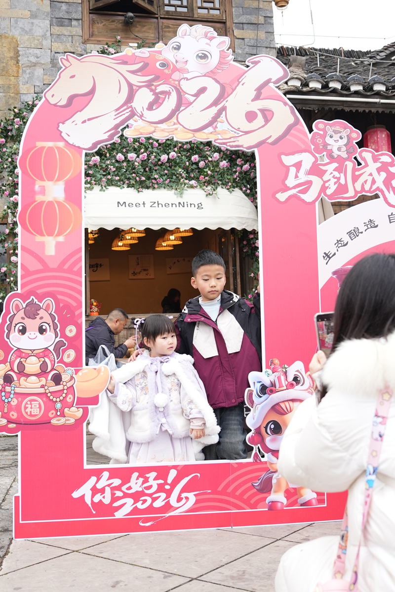 游客在鎮(zhèn)寧故事店前打卡。