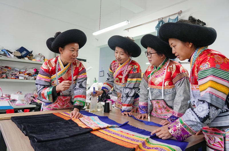 2026年1月5日,貴州省畢節(jié)市納雍縣豬場鄉(xiāng)富納蠟染刺繡農(nóng)民專業(yè)合作社,繡娘在裙褶縫制技巧。楊英攝