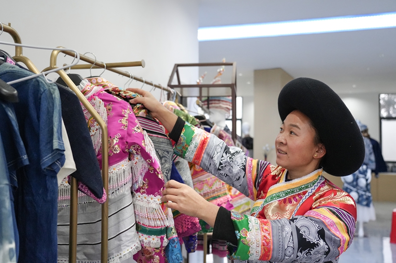 2026年1月5日,貴州省畢節(jié)市納雍縣豬場鄉(xiāng)富納蠟染刺繡農(nóng)民專業(yè)合作社,繡娘在整理服飾。 楊英攝