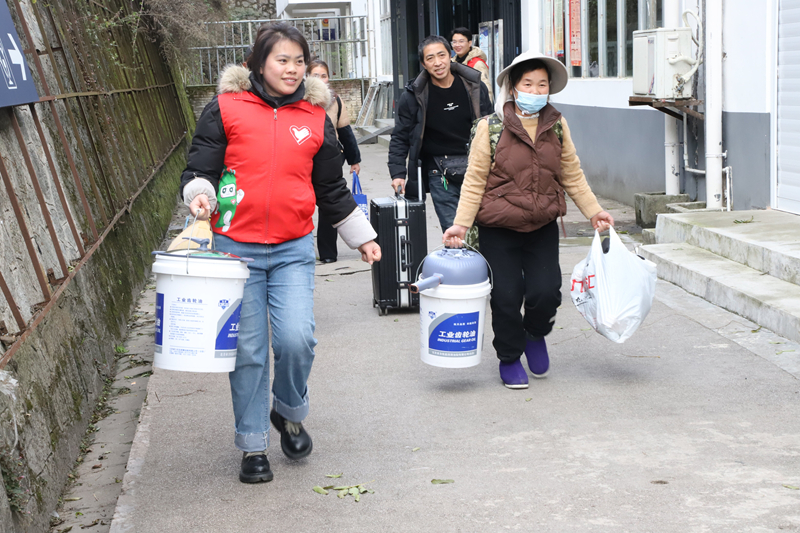 圖為施秉縣楊柳塘鎮志愿者正在火車站給返鄉的群眾搬運行李。