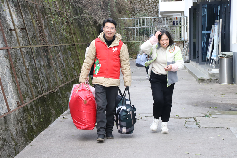 圖為施秉縣楊柳塘鎮志愿者正在火車站給返鄉的群眾搬運行李。
