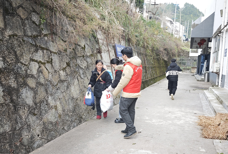 圖為施秉縣楊柳塘鎮志愿者正在火車站給返鄉的群眾搬運行李。