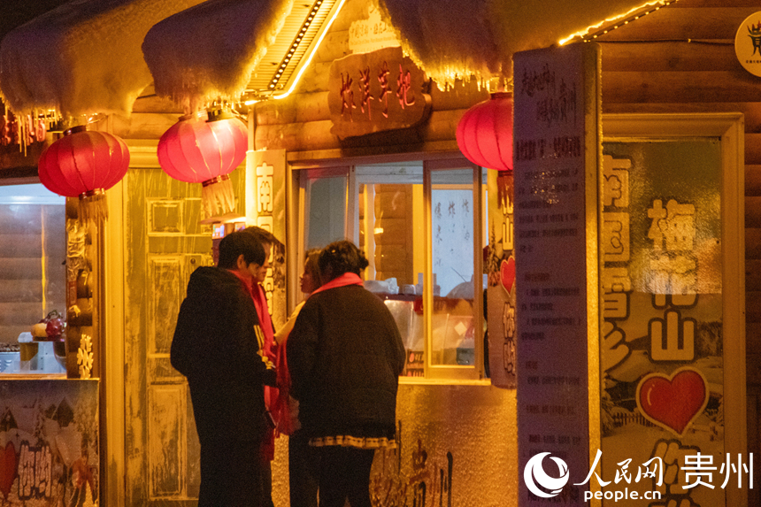 游客在“南國雪鄉”品嘗貴州特色美食“炸洋芋粑”。人民網 黃小桃攝