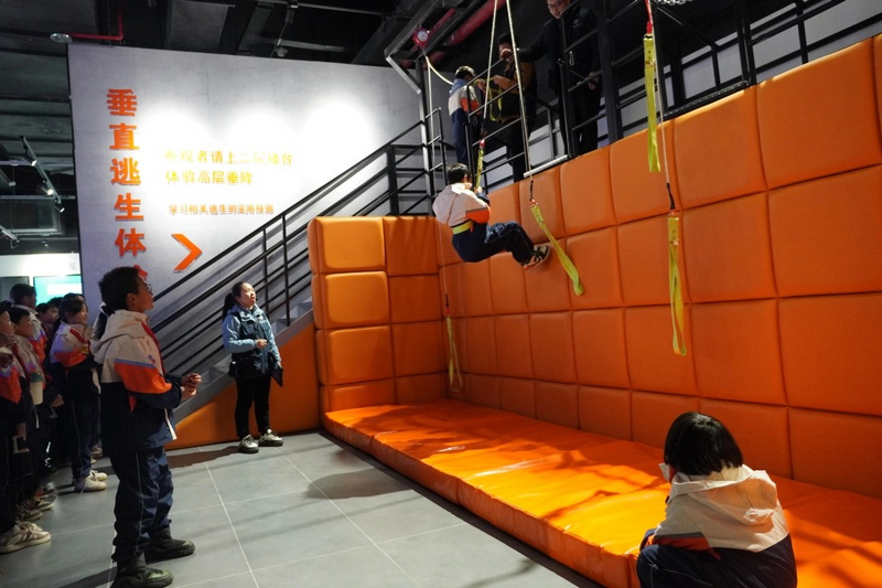 同學(xué)們排隊進(jìn)行垂直逃生體驗,學(xué)習(xí)相關(guān)逃生技巧。