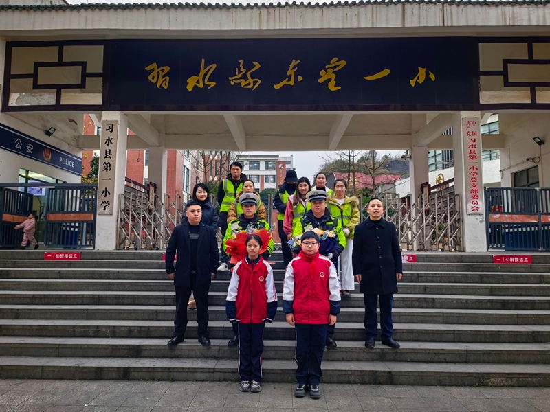 習水一小門前,少先隊員向交警獻花致敬,暖冬送溫情。.jpg