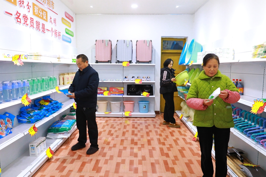 村民在積分超市挑選商品。謝達(dá)意攝。 (2)