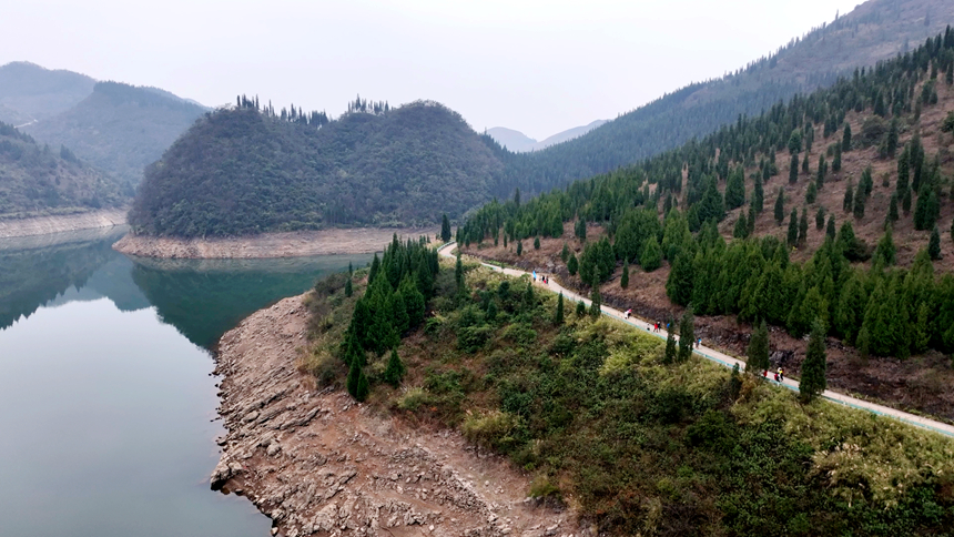 圖為游客在夜郎湖畔的果園與山道間穿行。