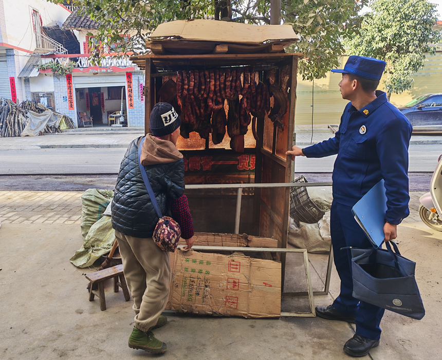 施秉縣鄉鎮專職消防員在向群眾宣傳熏臘肉中的消防安全。