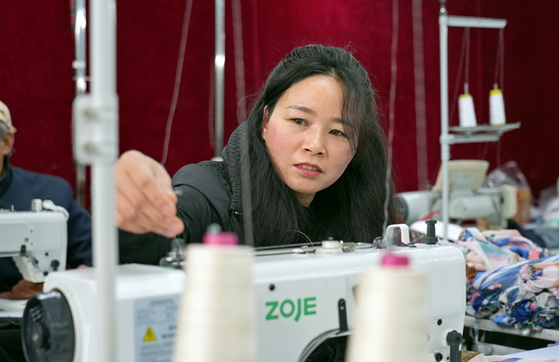 2026年1月12日，貴州省畢節市納雍縣化作鄉銀鑫制衣廠，工人在整理線。