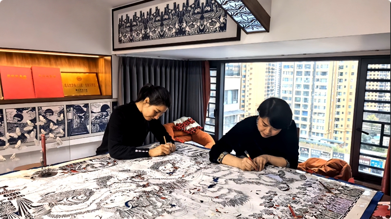 3、曹梅梅與江露莎合力制作剪紙作品。習(xí)水縣融媒體中心供圖