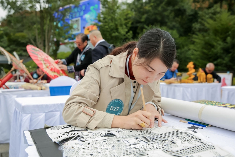 6、江露莎在活動(dòng)現(xiàn)場精細(xì)勾勒剪紙紋樣。習(xí)水縣融媒體中心供圖