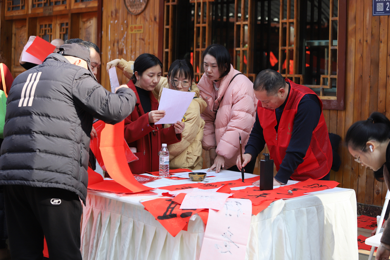 游客參與寫春聯活動。黎榮攝