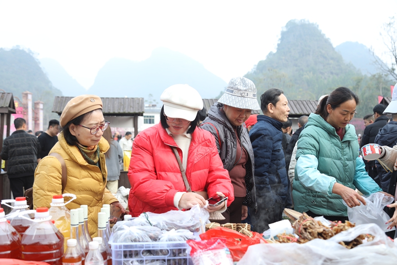 6 圖為梅花集市上，當(dāng)?shù)剞r(nóng)特產(chǎn)品及非遺手工藝品吸引游客爭(zhēng)相購(gòu)買。戴友維 攝.JPG