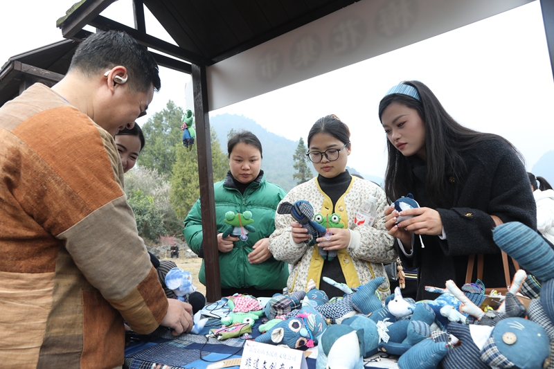 7 圖為梅花集市上，當(dāng)?shù)剞r(nóng)特產(chǎn)品及非遺手工藝品吸引游客爭(zhēng)相購(gòu)買。戴友維 攝.JPG