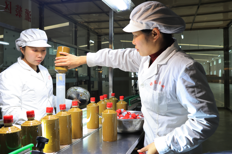 神龍酒業的包裝車間員工正在包裝酒。