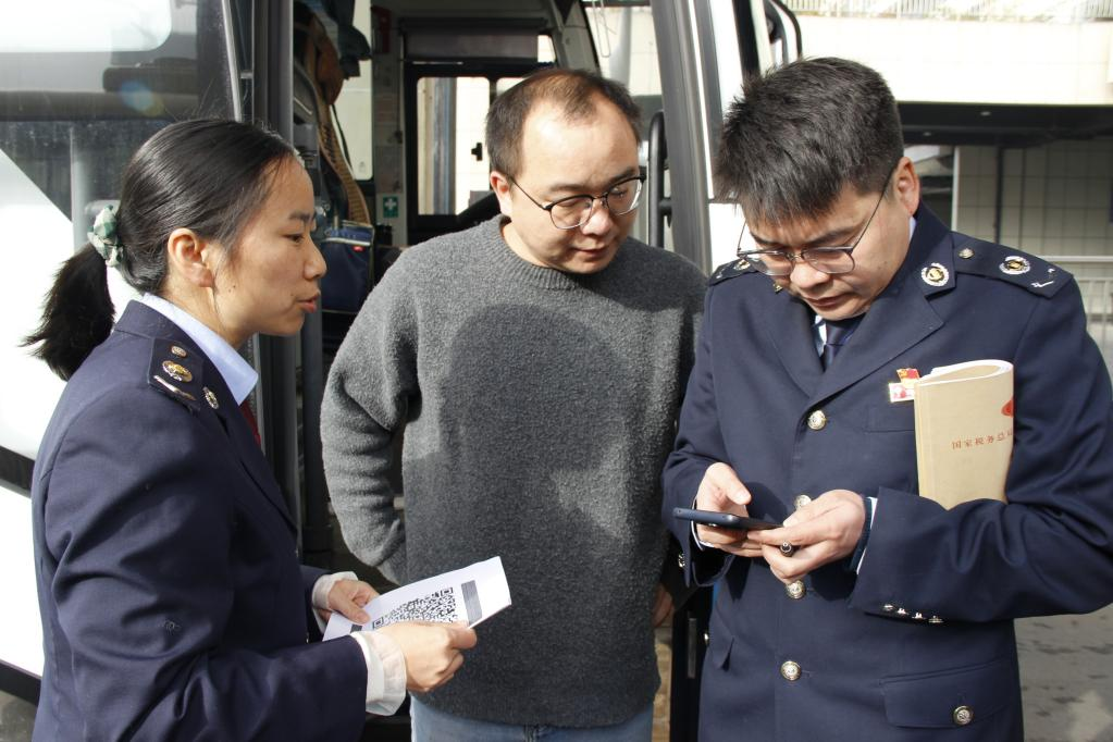 稅務(wù)干部輔導(dǎo)納稅人開具發(fā)票。鄧頔攝