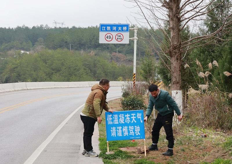 施秉縣甘溪鄉路段，工作人員在擺放提示牌。