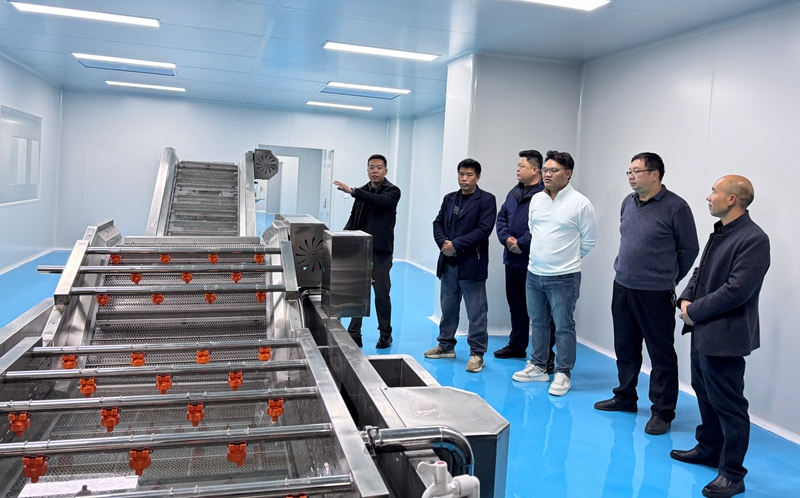 圖為開業(yè)活動(dòng)嘉賓們在參觀精品水果加工車間