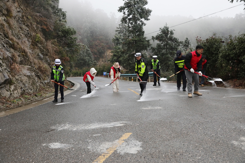 劍河縣公安局交通管理大隊民警與久仰鎮(zhèn)村干部、志愿者開展撒鹽除冰作業(yè)。岑光柱  攝1