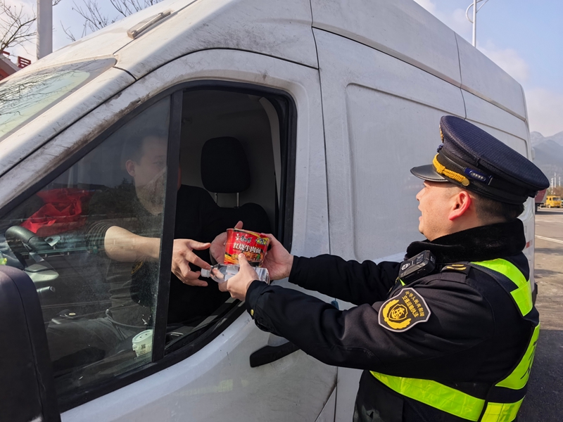 省交通執法七支隊二大隊執法人員向司乘人員發放應急食品。.jpg