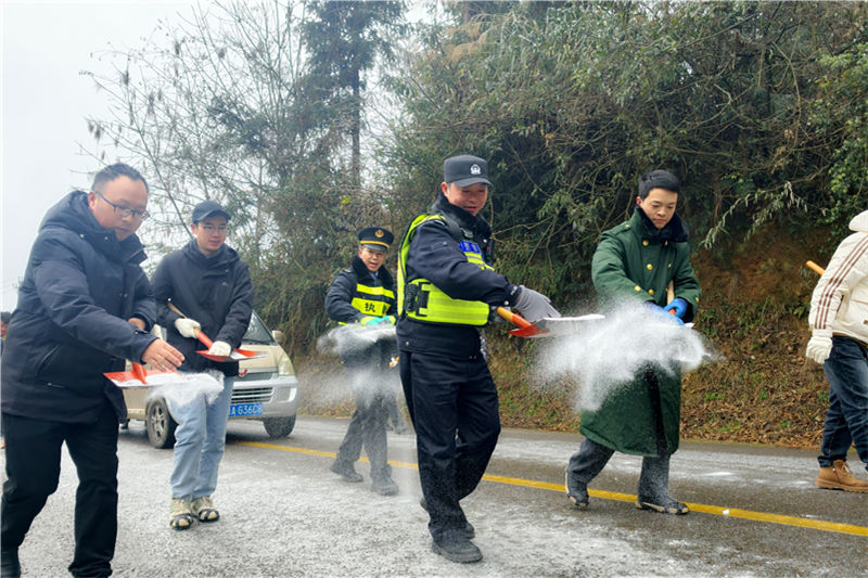民輔警與社區(qū)工作人員一起在凝凍路線上撒鹽。