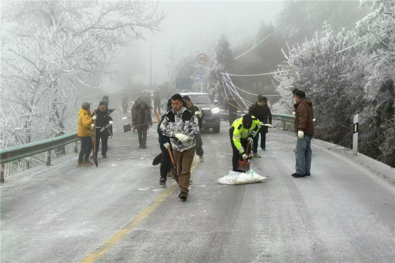 民輔警與社區(qū)工作人員一起在凝凍路線上撒鹽。