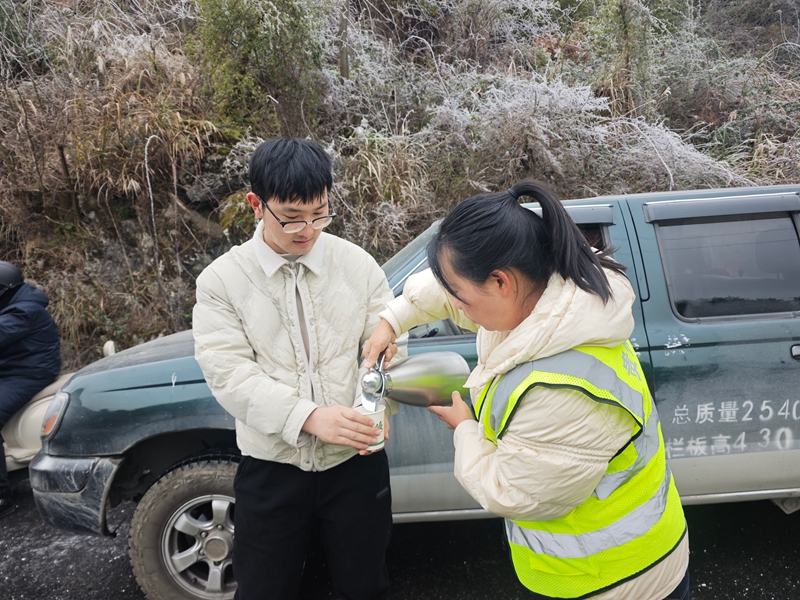 1 圖為在G210線為受困司機提供熱水。唐雨嘉 攝.jpg