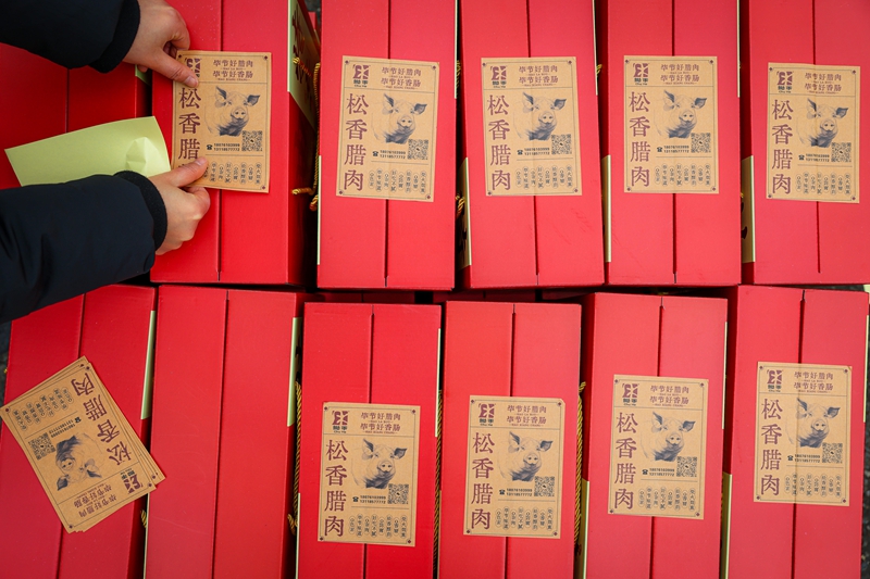 2026年1月26日，貴州省畢節(jié)市七星關(guān)區(qū)鋤禾農(nóng)特產(chǎn)品店工人給年貨禮盒貼標(biāo)簽。