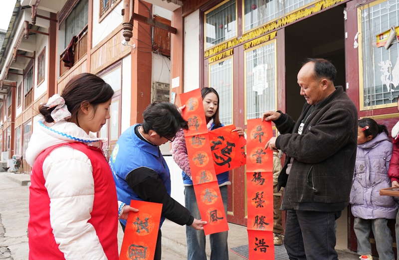 2026年1月26日，貴州省畢節(jié)市納雍縣張家灣鎮(zhèn)普灑社區(qū)，大學生志愿者在給群眾送春聯(lián)。