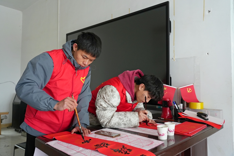 2026年1月26日,貴州省畢節市納雍縣張家灣鎮普灑社區,大學生志愿者在寫春聯。