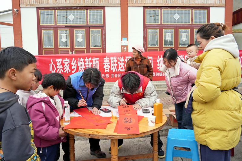 2026年1月26日，貴州省畢節(jié)市納雍縣張家灣鎮(zhèn)普灑社區(qū)，大學(xué)生志愿者在寫春聯(lián)。