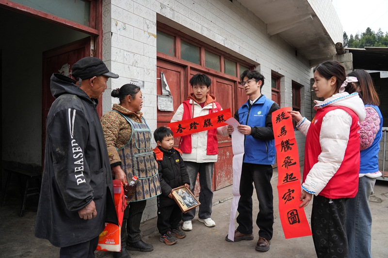 2026年1月26日,貴州省畢節市納雍縣張家灣鎮普灑社區,大學志愿者給特殊群眾送春聯。 楊英 攝.jpg