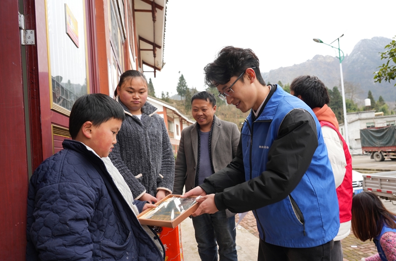 2026年1月26日,貴州省畢節市納雍縣張家灣鎮普灑社區,大學志愿者給小朋友送學習用品。 楊英 攝.jpg