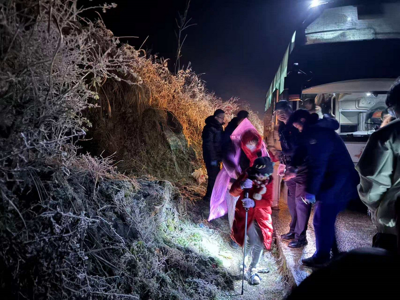 1月21日晚,救援人員組織被困游客離開凝凍路段。